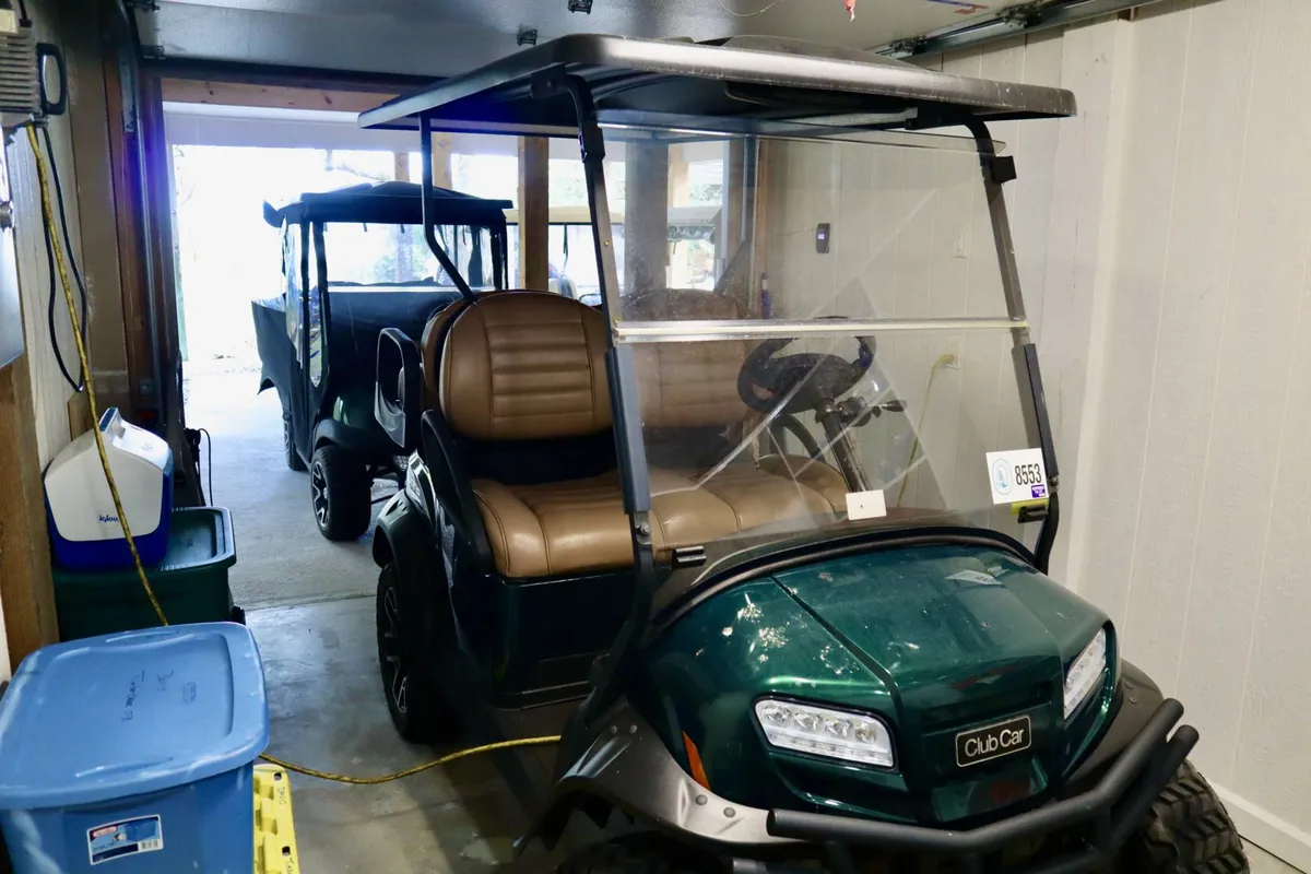 An inviting view inside a garage, with a family-friendly golf cart in the foreground and another cart in the background. The setup suggests ease of transport for island adventures, reinforcing the fun, casual atmosphere described in the section.