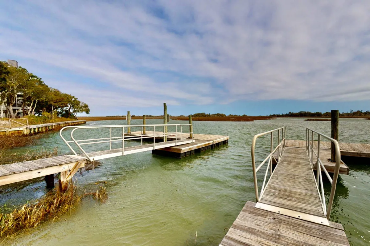 A peaceful dock extending over still water, surrounded by lush green foliage. The tranquil setting is ideal for fishing, relaxing, or launching a kayak—activities guests can enjoy right from the property.
